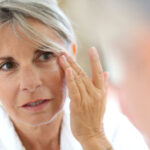 Senior woman applying anti-wrinkles cream