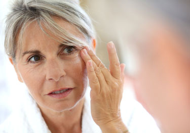 Senior woman applying anti-wrinkles cream