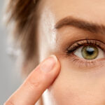 Close up of woman pointing finger to eye
