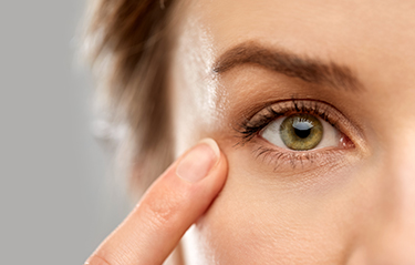 Close up of woman pointing finger to eye